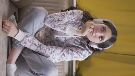 Vertical-video-of-Depressed-young-woman-listening-to-music-at-home-at-night.